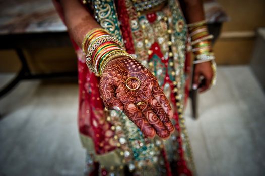 Indian bride henna hand holding grooms ring