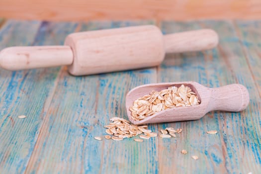 wood spoon with oats flakes pile on wood 