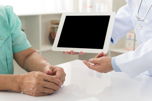 Doctors explain treatment to his patients. free space on tablet computer for your text.