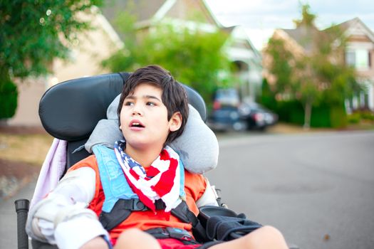 Young disabled boy in wheelchair looking up into sky