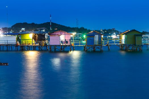 wooden house on the sea at night with color light