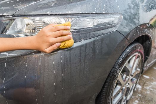 outdoor car wash with yellow sponge.