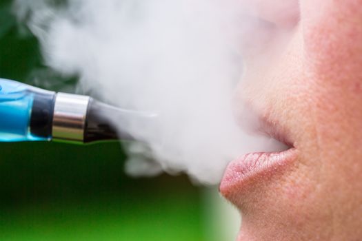A woman inhaling from an electronic cigarette
