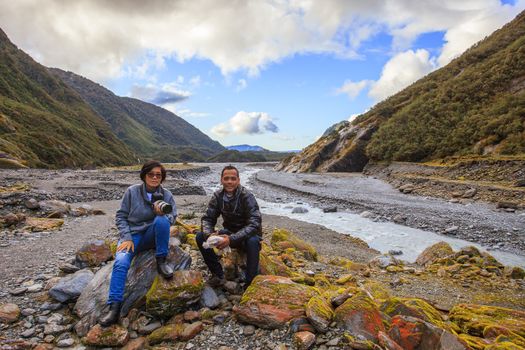 couples of asian traveler taking a photograph in franz josef gla