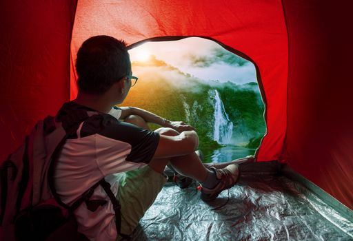 camping man in camper tent looking to beautiful natural water fa