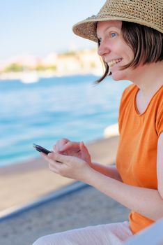 Beautiful adult caucasian woman using mobile phone on seaside va