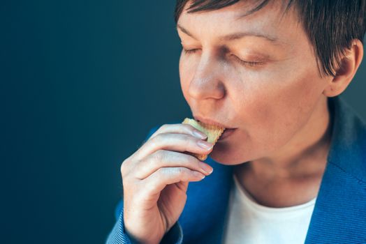 Businesswoman eating cookie on a break