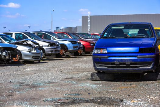 several cars in a scrap yard available for spare parts
