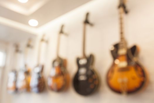 Blur abstract background with guitars hanging on white wall