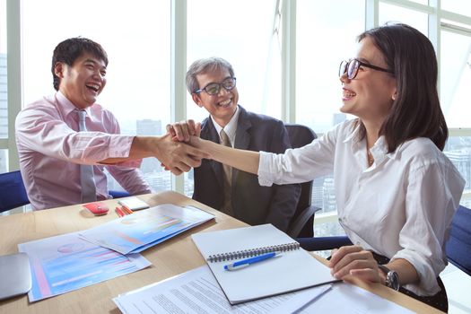 business team shaking hand and laughing happiness for successful