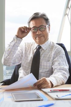 asian senior business man relaxing on working table