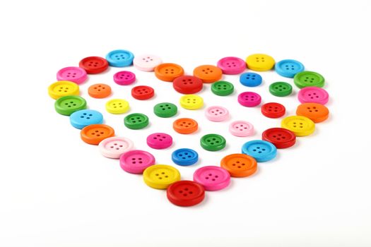 Heart shaped of colorful sewing buttons on white