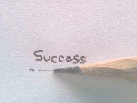 Hand writing success wording on paper with pencil