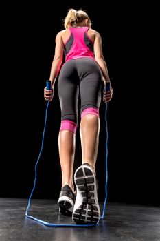 Sportswoman exercising with skipping rope