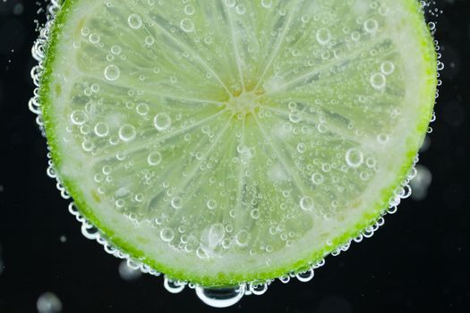 Lime slice falling into water