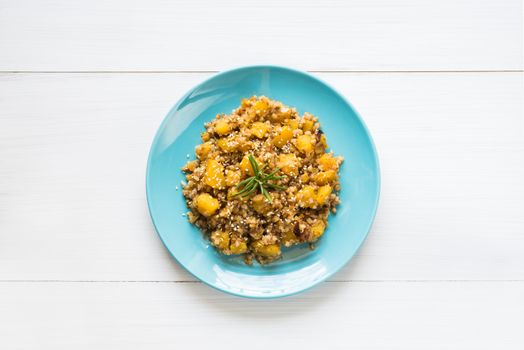 Plate of buckwheat stew with pumpkin on white table