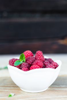 Fresh Raspberry Fruits In White Bowl on Wooden Table