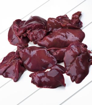 Heap of Fresh Raw Chicken Liver Cross Section on White Plank background