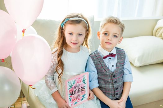 Siblings holding Mothers Day card