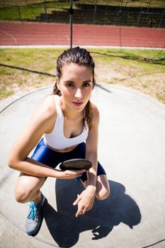 Portrait of confident female athlete holding a discus