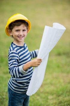 Boy in hard hat holding a plan