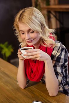 Young woman drinking coffee in cafeteria