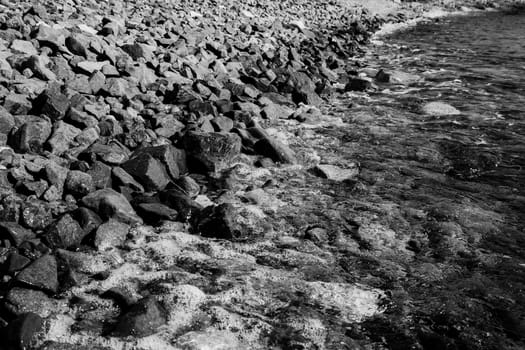 the waves rolled on shore with pebbles black and white