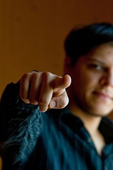 Young man pointing a finger to camera