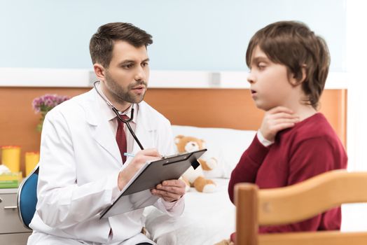 Man doctor with clipboard examining child patient with sore throat
