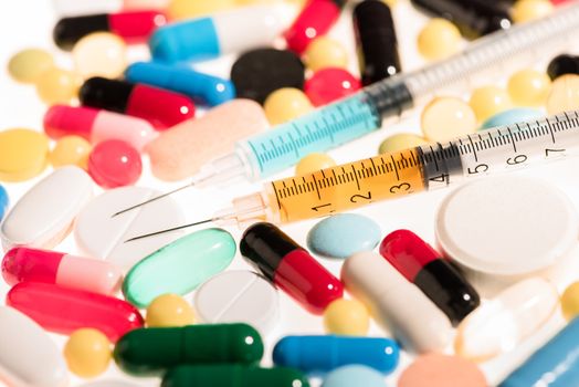 Close-up view of colorful medical pills and syringes, medicine and healthcare concept  