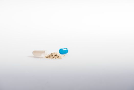Open capsule with medication on grey, medicine and healthcare concept   
