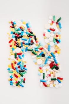 Top view of letter N made from medical pills and capsules, medicine and healthcare concept