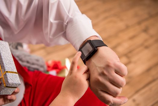 Cropped image of hand with smartwatch and child finger pointing on it