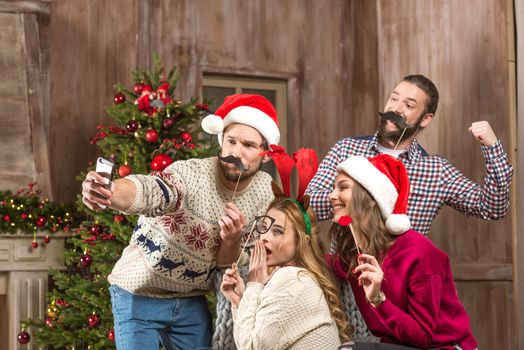 Happy people taking selfie at christmastime
