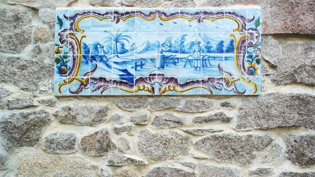 Detail of some azulejos and a stone wall