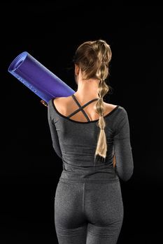 Sportswoman holding yoga mat 