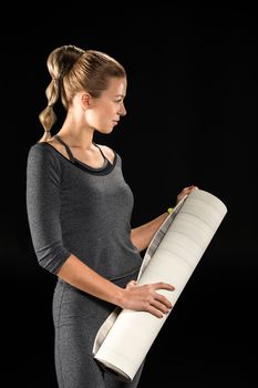 Sportswoman holding yoga mat 