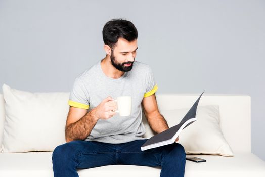 Bearded man reading magazine
