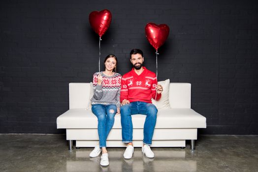 Couple with red hearts balloons