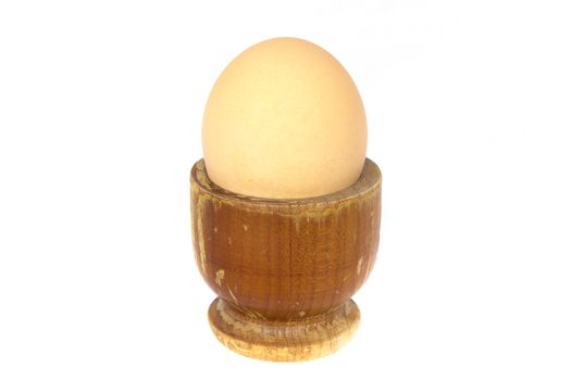 Boiled egg in wooden egg cup isolated on white