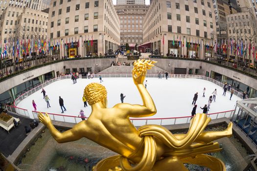 New York City, USA - March. 2015: Golden Prometheus statue and Rockefeller Center and tourists and ice skaters visiting Rockefeller Center ice skate rink on 24th of March,2015.