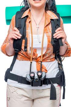 Girl tourist holds the straps of a large backpack close-up