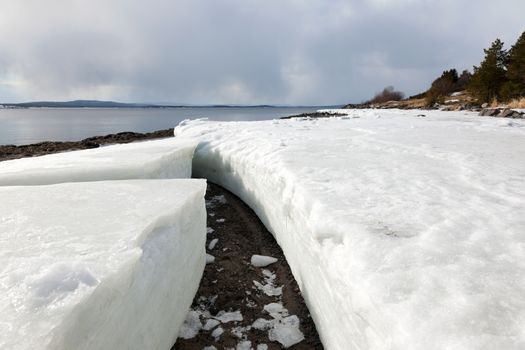 Lumps of ice on the shore of the northern sea during the period of thawing in the spring