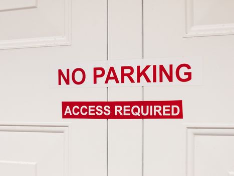 a white and red no paring access required sticker sign attached 