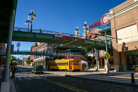 TAMPA, FLORIDA, US - November 29, 2003: Footbridges to Centro Ybor entrance with yellow tram underneath and visiting tourists, Tampa, FL
