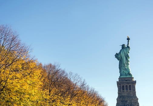 Statue of liberty with an autumnal foliage
