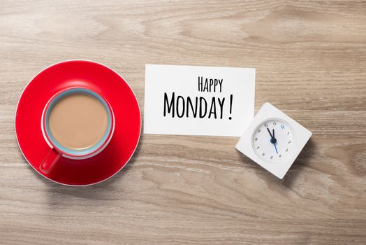 Happy Monday coffee cup on wooden background.