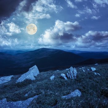 white sharp stones on the hillside at night in ful moon light