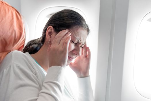 Portrait of a woman with a headache on an airplane