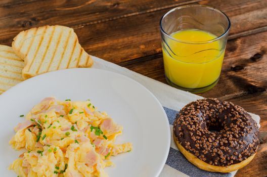 Scrambled eggs with toast and donut
